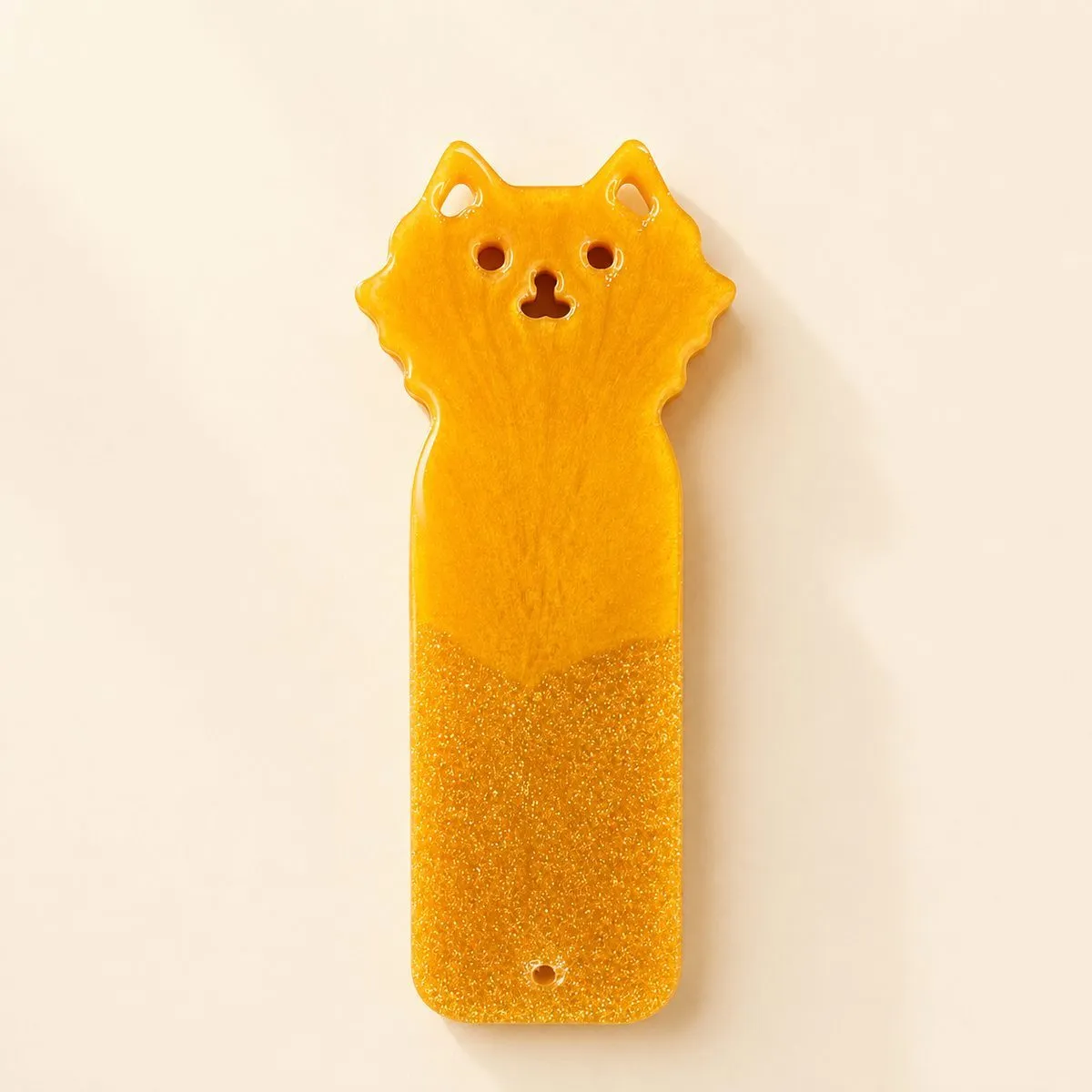 Amber cat bookmark with pointed ears, cut-out eyes and a ruffled collar