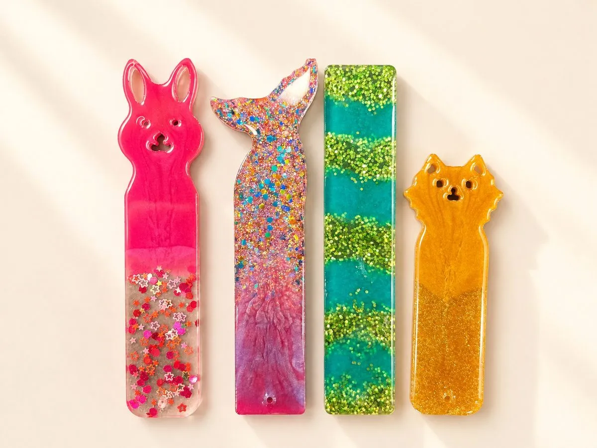 Four resin bookmarks fanned out: a bunny, a cat, a mermaid tail and a glitter rectangle