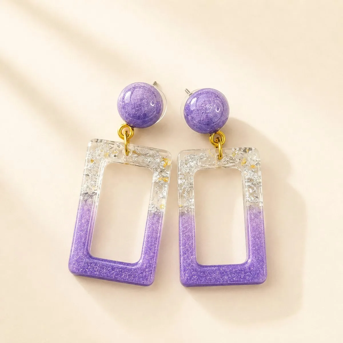 Purple shimmer stud above an open rectangular purple hoop edged with silver foil flake