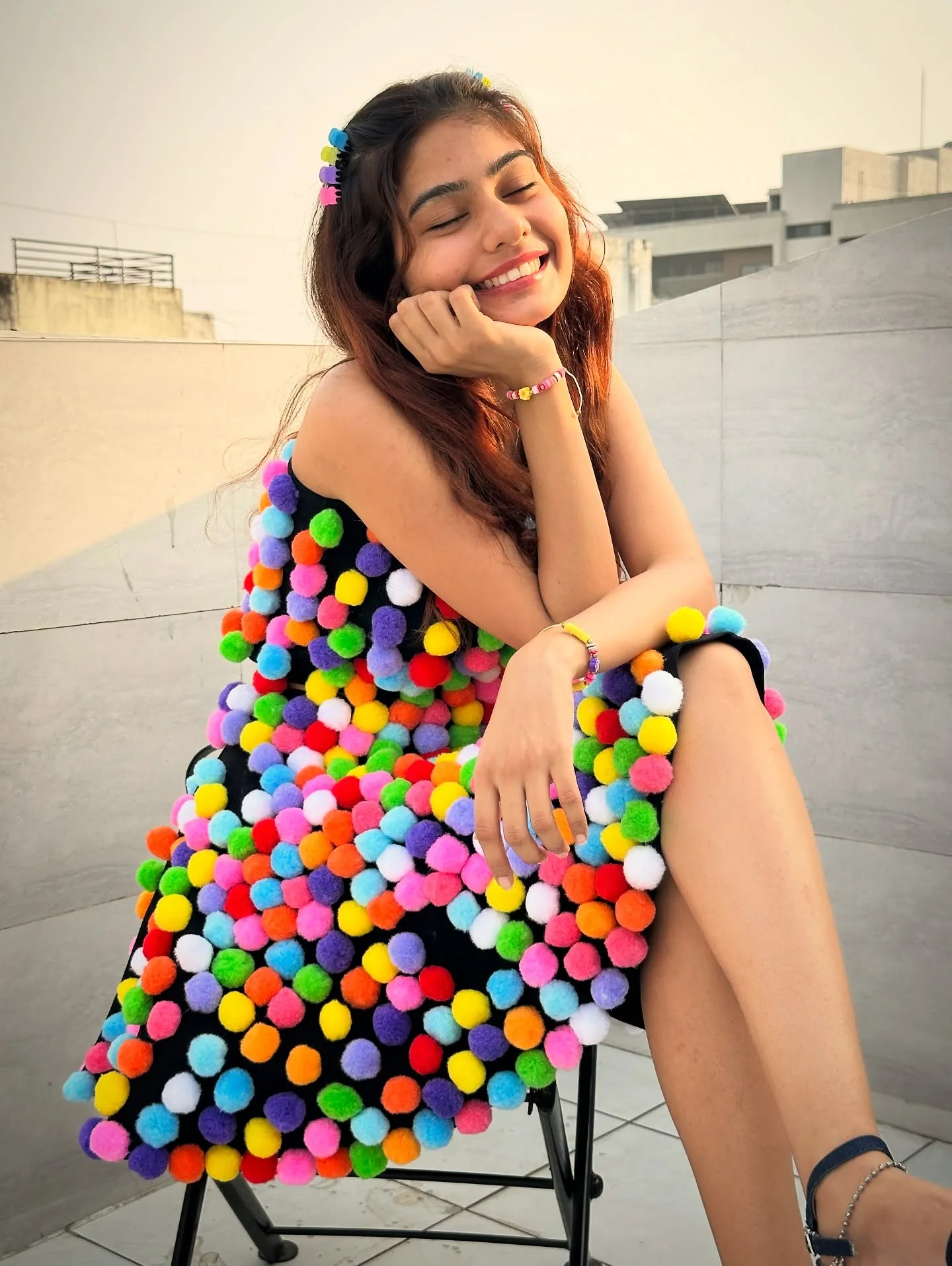 Gangotri, the maker behind Pixie Bloom, holding a pom-pom keychain