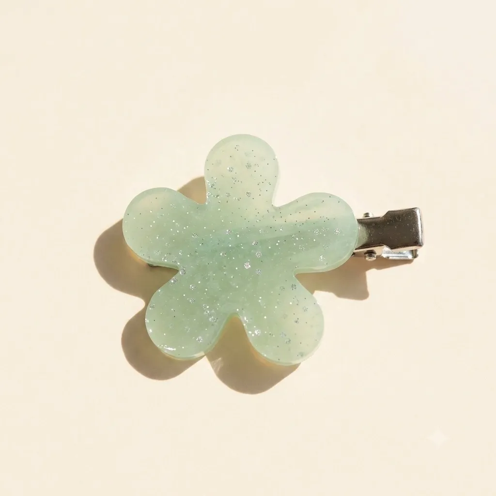 Pale mint green five-petal resin flower hair clip with fine silver glitter, on a silver alligator clip