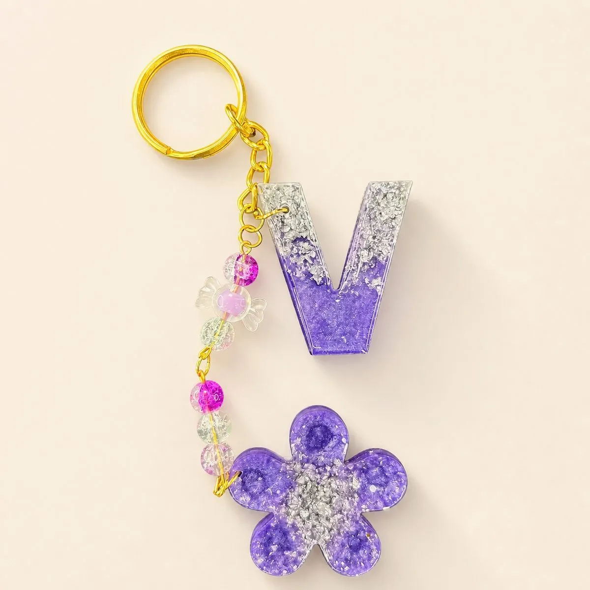 Purple letter V keychain with chunky silver foil flake and a purple flower charm